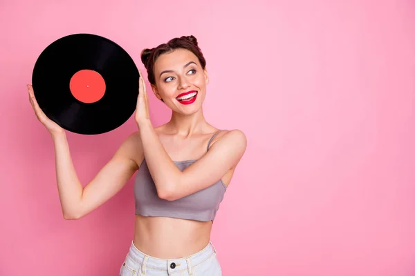 Porträtt av härlig söt flicka musik älskare hålla vinylplatta grammofon skiva vill ha retro parti slitage casual stil kläder isolerade över rosa färg bakgrund — Stockfoto