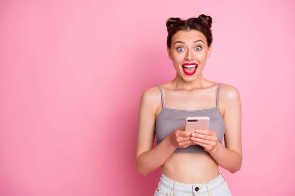Portré megdöbbent lány használ okos telefon kap a szociális média, mint a bejelentés sikoly wow omg viseljen szép ruhát elszigetelt rózsaszín szín háttér — Stock Fotó