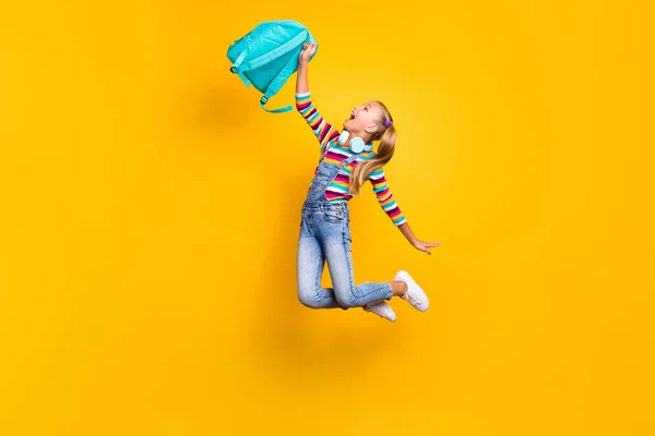 원문 기사보기 미국 학생들 이 1 차 학교 수업을 즐기고 있는 파란 가방 배낭을 들고 밝은 노란색 배경을 가진 점퍼 데님 청바지 운동화를 신고 있다. — 스톡 사진