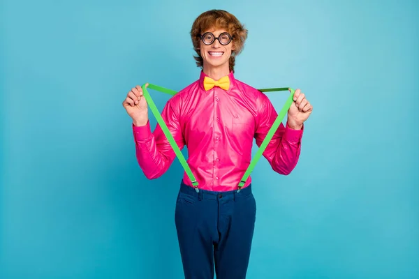 Porträt von positiven fröhlich Nerd Kerl fühlen sich sorglos ziehen seine stilvollen Hosenträger tragen gutes Aussehen helles Outfit isoliert über blauem Hintergrund — Stockfoto