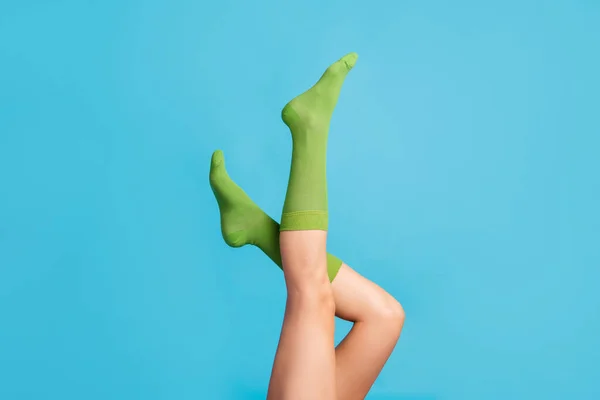 Parlak parlak parlak parlak mavi arka plan üzerinde izole edilmiş, rahat, yeşil brandy çoraplar giyen çekici, uzun bacakların yan görüntüsü. — Stok fotoğraf