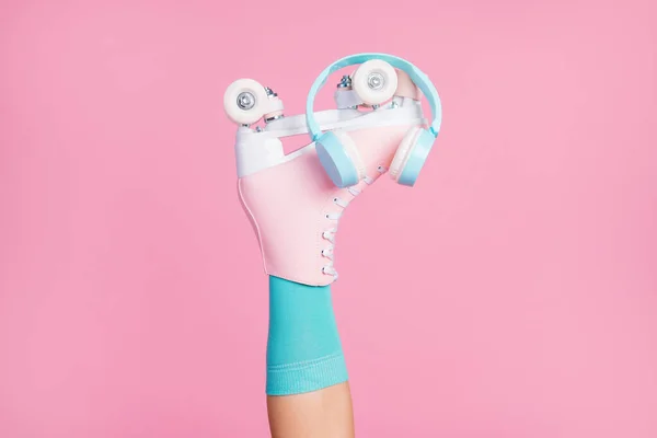 Vista recortada de una bonita y atractiva pierna única con patines de calcetines azules auriculares moderno éxito de radio de moda aislado sobre fondo de color pastel rosa — Foto de Stock