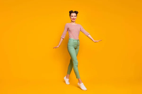 Foto de perfil de comprimento total de senhora muito atraente andando rua viciado viajante desgaste listrado camisa branca vermelha calças verdes tênis isolado cor amarela fundo — Fotografia de Stock