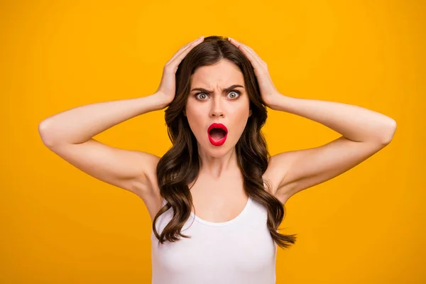 Closeup photo of funny pretty lady open mouth displeased facial expression bad terrible situation arms on head wear white tank-top isolated bright yellow color background — Stok fotoğraf