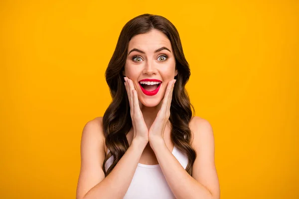 Closeup photo of beautiful pretty lady open mouth arms on cheeks positive good mood long brunette hairdo surprised wear white tank-top isolated bright yellow color background — 스톡 사진