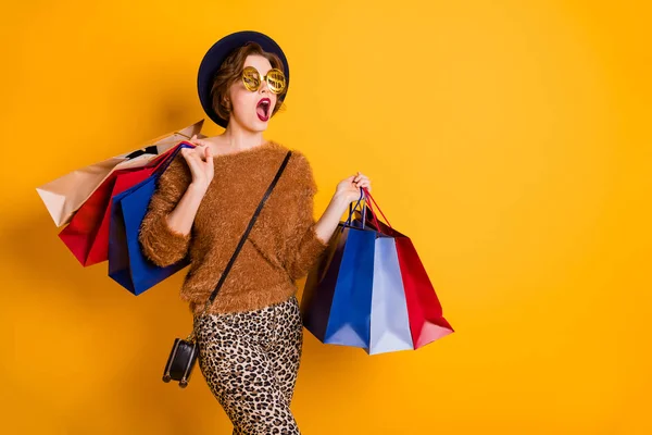 Foto der starrenden Dame mit offenem Mund aussehen leeren Raum Verkauf Einkaufszentrum viele Packungen tragen weiche Pullover Leopardenhose Retro-Mütze Umhängetasche Spezifikationen isoliert gelbe Farbe Hintergrund — Stockfoto