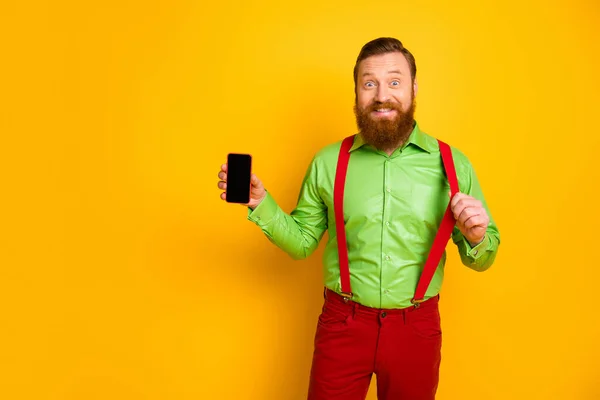 Portrait of cheerful man hold smartphone new modern technology product recommend promo pull stylish suspenders wear good look clothes isolated over yellow color background — Stok fotoğraf