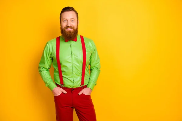 Photo of excited happy red head guy toothy smiling elegant look came party wear bright green shirt red suspenders bow tie trousers isolated yellow color background — Stock fotografie