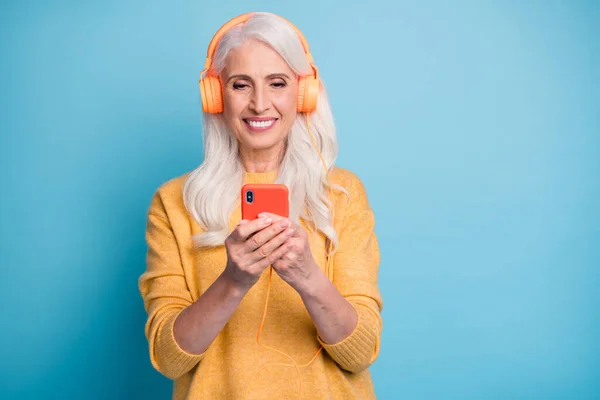 Close-up portrait of nice-looking attractive lovely adorable winsome cheerful cheery grey-haired woman listening radio hit pop single isolated on bright vivid shine vibrant blue color background — Stockfoto