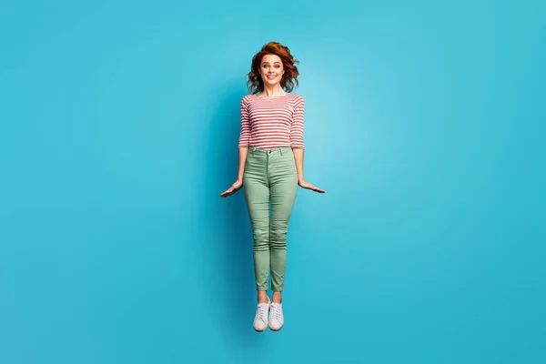 Foto de longitud completa de hermosa dama saltando en alto regocijo fin de semana buen tiempo día soleado desgaste casual rojo blanco camisa verde pantalones calzado aislado azul color fondo — Foto de Stock