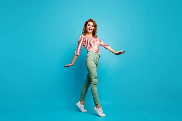 Full body profile photo of funny lady enjoy warm spring day spend active time walk street wear casual red white pullover green pants footwear isolated blue color background — Stockfoto