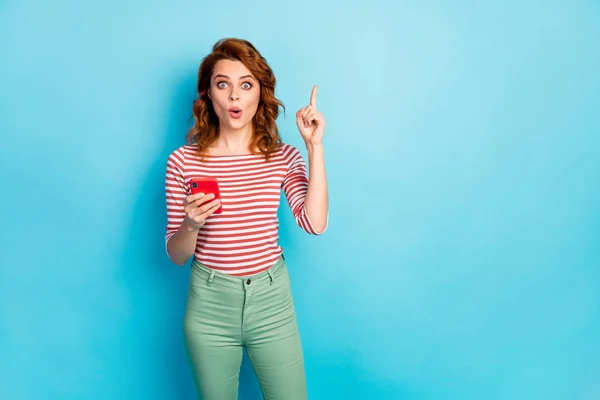 Portrait of astonished woman use cellphone chatting post think thoughts have question answer raise index finger up impressed scream wow omg wear sweater isolated blue color background — ストック写真