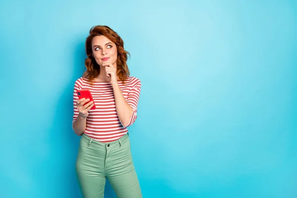 Portrait of minded inspired girl addicted social media user use cellphone think thoughts post comment wear stylish pullover isolated over blue color background — Stock Fotó