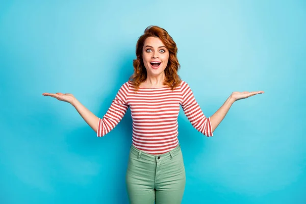 Portrait of astonished funky mature woman hold demonstrate unbelievable adverts recommend suggest select incredible promotion wear white jumper isolated over blue color background — ストック写真