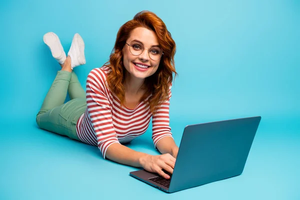Full body close up photo of positive cheerful woman lie floor work computer communicate with friends colleagues wear white good look sweater isolated over blue color background