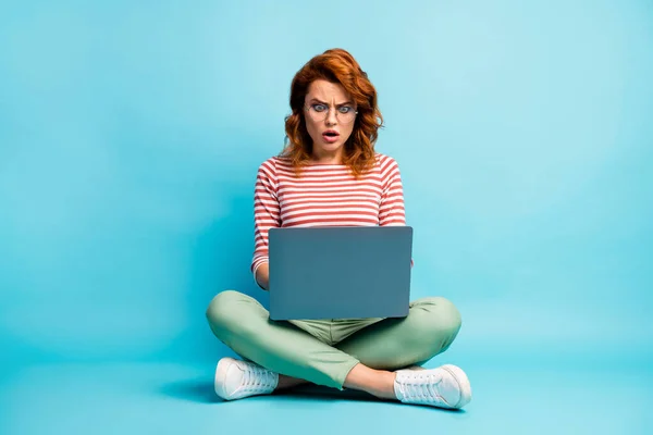 Полное фото тела расстроенной девушки сидеть крест работы компьютер читать информацию в социальных сетях впечатлен крик невероятный неожиданный носить стильные туфли наряд изолированный синий цвет фона — стоковое фото