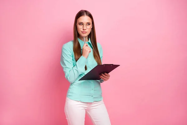 Thoughtful minded professional smart girl think thoughts hold clip board decide work start-up decisions pen touch chin look copyspace wear turquoise pants isolated pastel color background — Stock fotografie