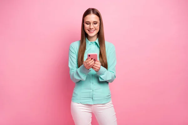 Retrato de niña alegre positiva uso smartphone leer red social novedad desgaste buen aspecto traje de color turquesa aislado sobre fondo de color pastel —  Fotos de Stock