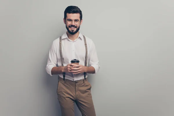 Positive cheerful smart gentleman promoter guy rest relax in cafeteria hold take-away cup with cappuccino wear good look modern clothes isolated over grey color background — Stock fotografie