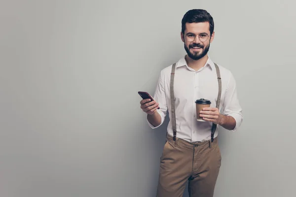 Positive cool attorney man student hold take-out mug beverage latte use smartphone follow social network news wear formalwear white shirt brown pants trousers isolated grey color background — 스톡 사진