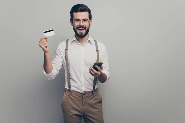 Cheerful positive energetic collar man use smart phone get sms savings earnings pay bills with plastic card enjoy rejoice wear white shirt pants trousers isolated grey color background — Stockfoto