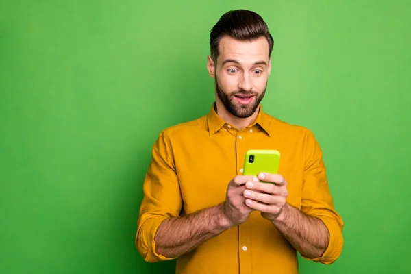 Portrait de son il agréable attrayant mec barbu gai et étonné en chemise formelle en utilisant un service de technologie moderne isolé sur un brillant vif fond de couleur vert vif — Photo