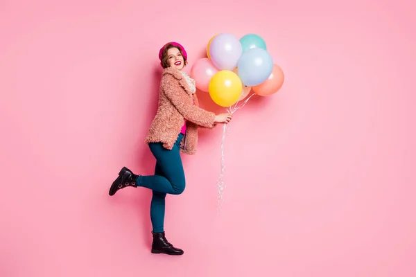 Foto de longitud completa de la señora bonita celebrar muchos globos de aire coloridos cumpleaños sorpresa para amigo usar abrigo de piel elegante bufanda boina gorra pantalones zapatos ropa aislado color rosa fondo — Foto de Stock