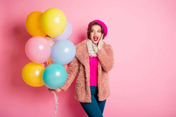 Foto de señora bastante funky sostienen muchos globos de aire coloridos mano excitada en la barbilla cumpleaños sorpresa desgaste casual abrigo de piel elegante bufanda boina gorra ropa aislado color rosa fondo —  Fotos de Stock