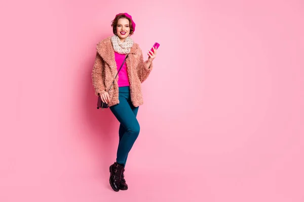 Full length φωτογραφία του χαριτωμένο ταξιδιώτη κυρία κρατήσει τηλέφωνο με τα πόδια κάτω από το δρόμο κάνοντας εικόνες φορούν casual γούνα άνοιξη παλτό μπερέ παντελόνι παπούτσια συμπλέκτη στολή απομονωμένο ροζ χρώμα φόντο — Φωτογραφία Αρχείου