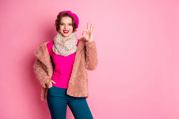Porträtt av positiva ganska söt flicka visa okej tecken rekommenderar annonser marknadsföring bära pastell kläder ljusa läppstift tröja isolerad över rosa färg bakgrund — Stockfoto