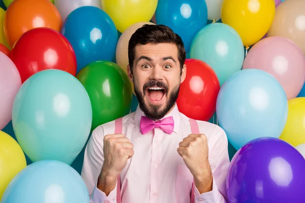 Φωτογραφία του αστείο όμορφος άντρας πολύχρωμο διακοσμήσεις έτοιμο πάρτι εορταστική διάθεση αυξήσει γροθιές πληρούν τους επισκέπτες φορούν ροζ πουκάμισο παπιγιόν τιράντες σε μπαλόνια δημιουργικό σχεδιασμό φόντο — Φωτογραφία Αρχείου