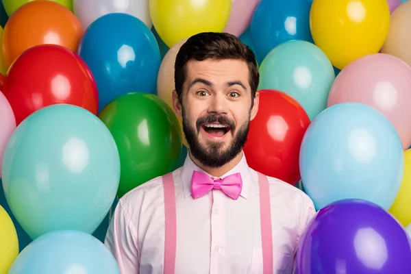 Foto de divertido loco chico boca abierta colorido diseño ambiente sorprendido cumpleaños fiesta formalwear rosa camisa lazo tirantes en brillante muchos globos fondo creativo —  Fotos de Stock