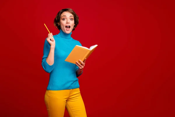 놀란 소녀가 노트를 만들어 쓰기 프로젝트 복사기 책은 훌륭 한 아이디어의 비명 과 와우 OMG 가 연필을 들어 청색 점퍼노란 바지를 입고 밝고 붉은 색 배경을 갖고 있다. — 스톡 사진