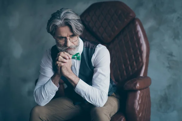 Portrait de mâle superbe vieux propriétaire de l'entreprise assis fauteuil regarder copyspace rêve porter des vêtements modernes pointillés isolés sur fond de couleur grise — Photo