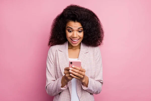 美しい興奮暗い肌の女性の写真電話の手を保持正のブログ投稿を読むコメントを開く口の摩耗チェッカーブレザー孤立パステルピンク色の背景 — ストック写真