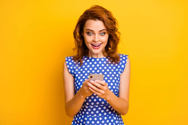 Photo attrayant foxy dame modèle tenir les mains du téléphone bouche ouverte lire les bonnes nouvelles e-mail porter rétro pois bleu blanc chemise isolé couleur jaune fond — Photo