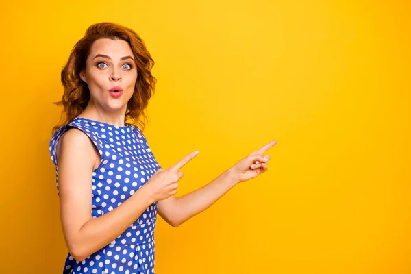 Foto de perfil de atractiva señora zorra rizada indican dedos espacio vacío nuevo centro comercial apertura presentación desgaste retro punteado azul camisa aislado amarillo color fondo — Foto de Stock