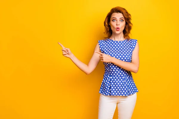 Retrato de ella ella agradable atractivo encantador sorprendido alegre alegre alegre chica de pelo ondulado mostrando espacio de copia regalo anuncio presente aislado en brillante brillo vivo vibrante color amarillo fondo —  Fotos de Stock