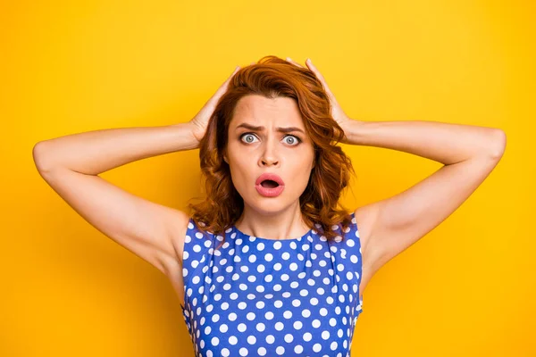 Closeup photo of terrified pretty wavy ginger lady holding arms on head open mouth listen terrible news wear retro style dotted blue white shirt isolated yellow color background — Stock Photo, Image