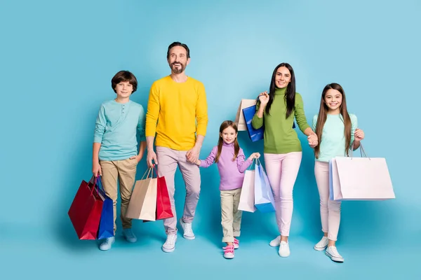 Pleine longueur la taille du corps vue de belle belle belle joyeuse famille portant des sacs de nouvelles choses vêtements passer jour noir vendredi isolé sur brillant vif éclat vibrant fond de couleur bleue — Photo