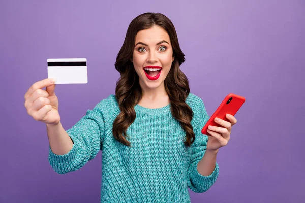 漂亮的经理女士拿着电话建议低价购物的照片，网上显示新信用卡付款穿蓝色套头衫孤立的紫色背景 — 图库照片
