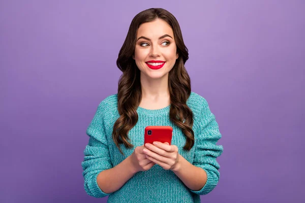 Foto der hübschen Dame halten Telefon Jugend beliebte Blogger schauen gewundert Seite leeren Raum roten Lippenstift Pomade tragen blauen Strickpullover isoliert lila Farbe Hintergrund — Stockfoto