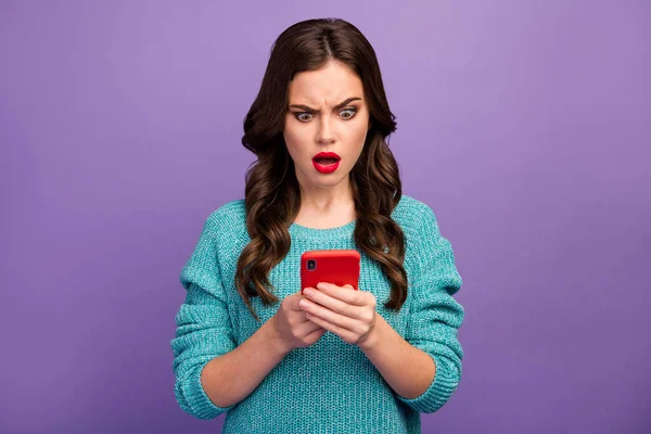 漂亮漂亮的波浪形女士红口红的照片拿着电话读坏消息负面评论后张嘴穿蓝色套头衫孤立的紫色背景 — 图库照片