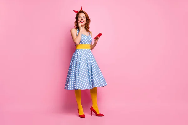 Full body photo of beautiful funny lady hold telephone read good comments blog wear headband dotted dress long skirt red stilettos yellow stockings isolated pink color background — 스톡 사진