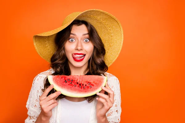 Photo of curly wavy cheerful casual positive nice cap charming white youngster licking her upper lip holding a wedge of watermelon with lips pomaded willing to eat isolated over vivid color background — ストック写真