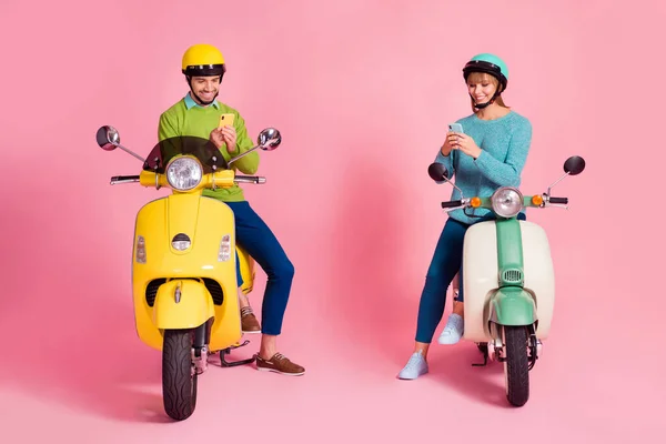 Helkroppsfoto av rolig kvinna kille två personer som kör vintage moped semester tillsammans kort sluta bläddra telefon slitage casual tröja huvudbonad isolerad rosa färg bakgrund — Stockfoto