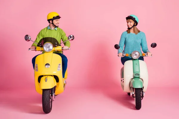 Foto de corpo inteiro de senhora engraçada cara dirigindo dois vintage moped passar férias juntos estrada segura conhecer aventuras usar roupa casual capacete colorido isolado cor rosa fundo — Fotografia de Stock