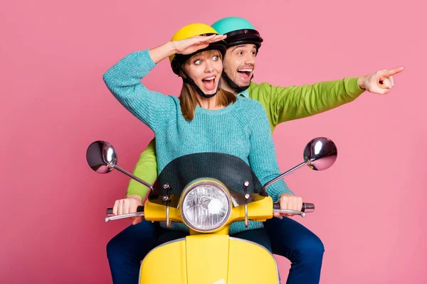 Fotografie legrační dáma chlap dva lidé řízení vintage moped strávit dovolenou přímý prst prázdný prostor vidět cool budova nosit ležérní oblečení barevné pokrývky hlavy izolované růžové barvy pozadí — Stock fotografie