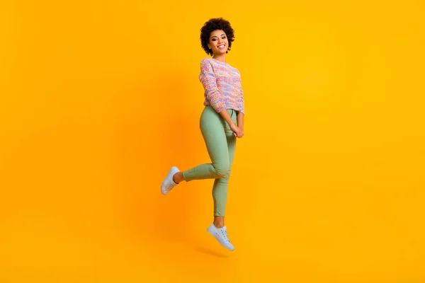 Foto de corpo inteiro de bonito doce afro americano menina salto desfrutar de outono primavera tempo livre sentir emoções despreocupadas desgaste bom look roupa isolada sobre cor amarela fundo — Fotografia de Stock