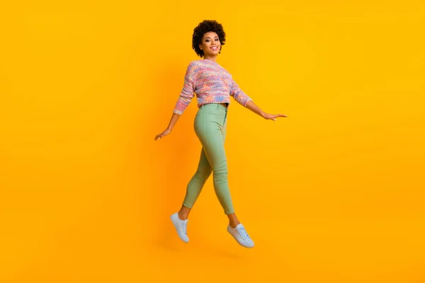 Full length photo of cheerful dreamy afro american girl jump enjoy fall spring free time wear casual style clothes isolated over shine color background — Stock Photo, Image